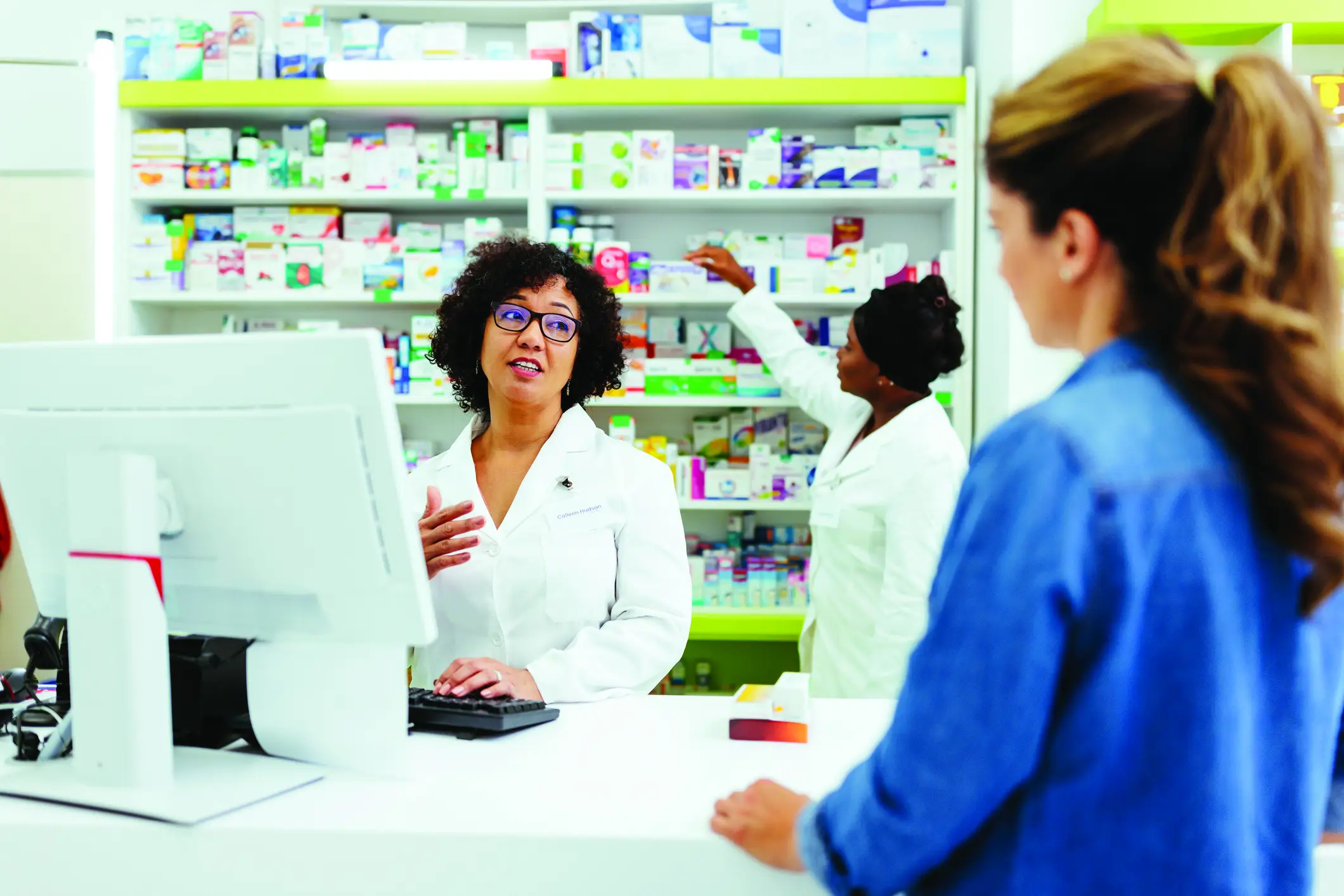 Pharmacist speaking with a customer at the counter
